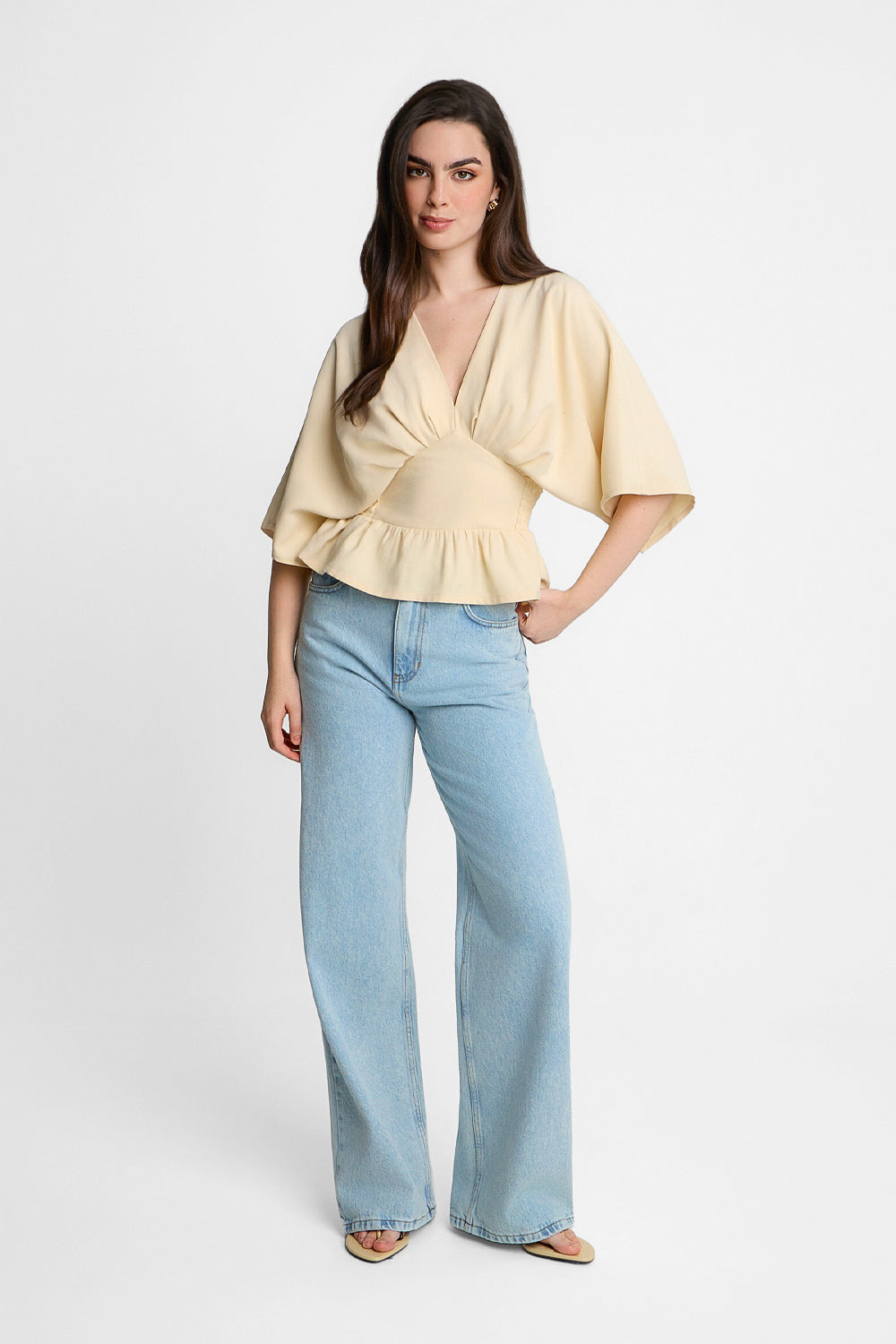 An elegant cream-coloured women’s blouse with a peplum and a V-neck | Ansin